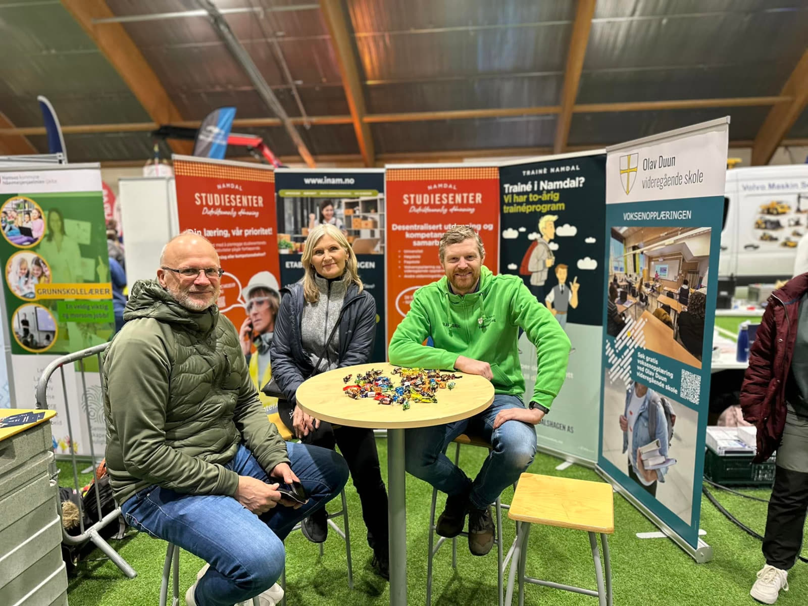 Utstillere i prat ved et bord på arenaen